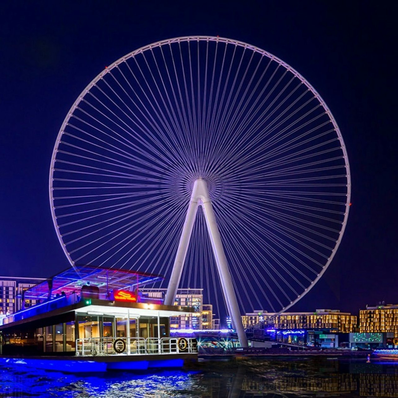 Experience the magic of Dubai at night as you sail past Ain Dubai enjoying stunning views of illuminated skyscrapers and the serene waters perfect for creating unforgettable memories with loved ones.
